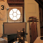 A room with a baseball uniform and a window.