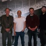 A group of men standing in front of an image.