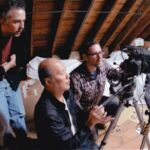 Three men are filming a video in the attic.