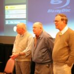 John Sylvester Jr, My dad - Phil Lilley, and Charlie Poekel (author of Babe & The Kid) Three men standing in front of a projector screen.