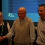 Mike Quinlan, John Sylvester Jr and Producer : Director Andrew Lilley Three men standing next to each other in front of a projector screen.