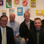 At Bergino's in Manhattan where the trailer for 'I'll Knock a Homer for You' is debuted. (from left: Jay Goldberg, Charlie Poekel, John Sylvester Jr., Ted Keenan, Andrew Lilley, and Philip Lilley) A group of men sitting in front of wall with various signs.