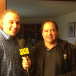 Producer/Director/Editor Andrew Lilley being interviewed by 1010 WINS Reporter John Montone about "I'll Knock a Homer for You" A man and a woman are standing in front of a microphone.
